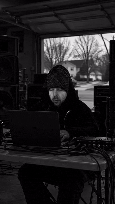 Independent researcher working at a laptop in an open garage